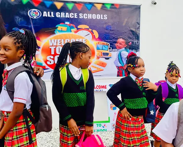 Pupils with school bags in front of a welcome-to-school banner