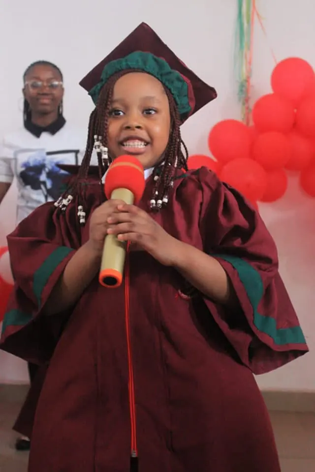 A graduating pupil speaking into a microphone