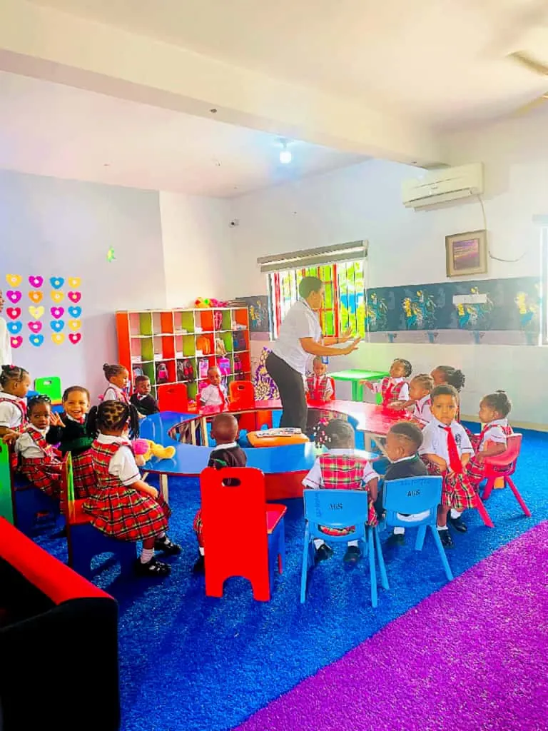 Young pupils seated around low tables in a kindergarten class