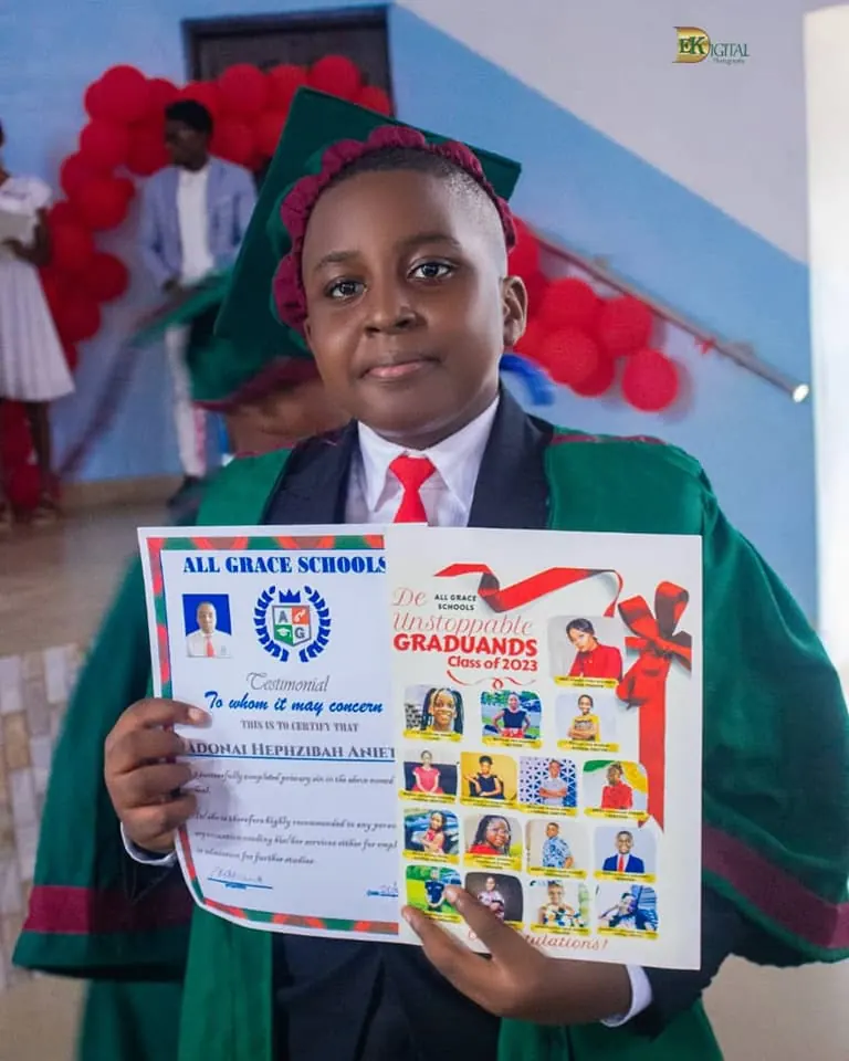 A graduating pupil in gown and cap holding a certificate
